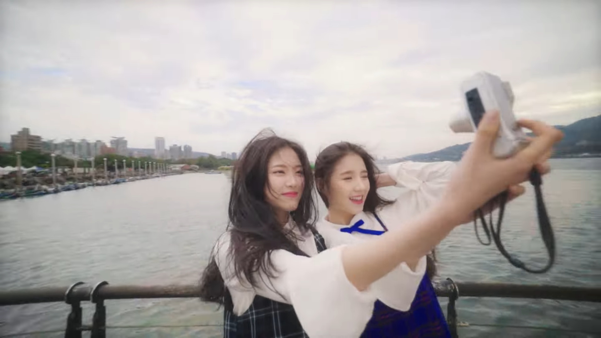 Heejin and Hyunjin taking a selfie in front of a lake.